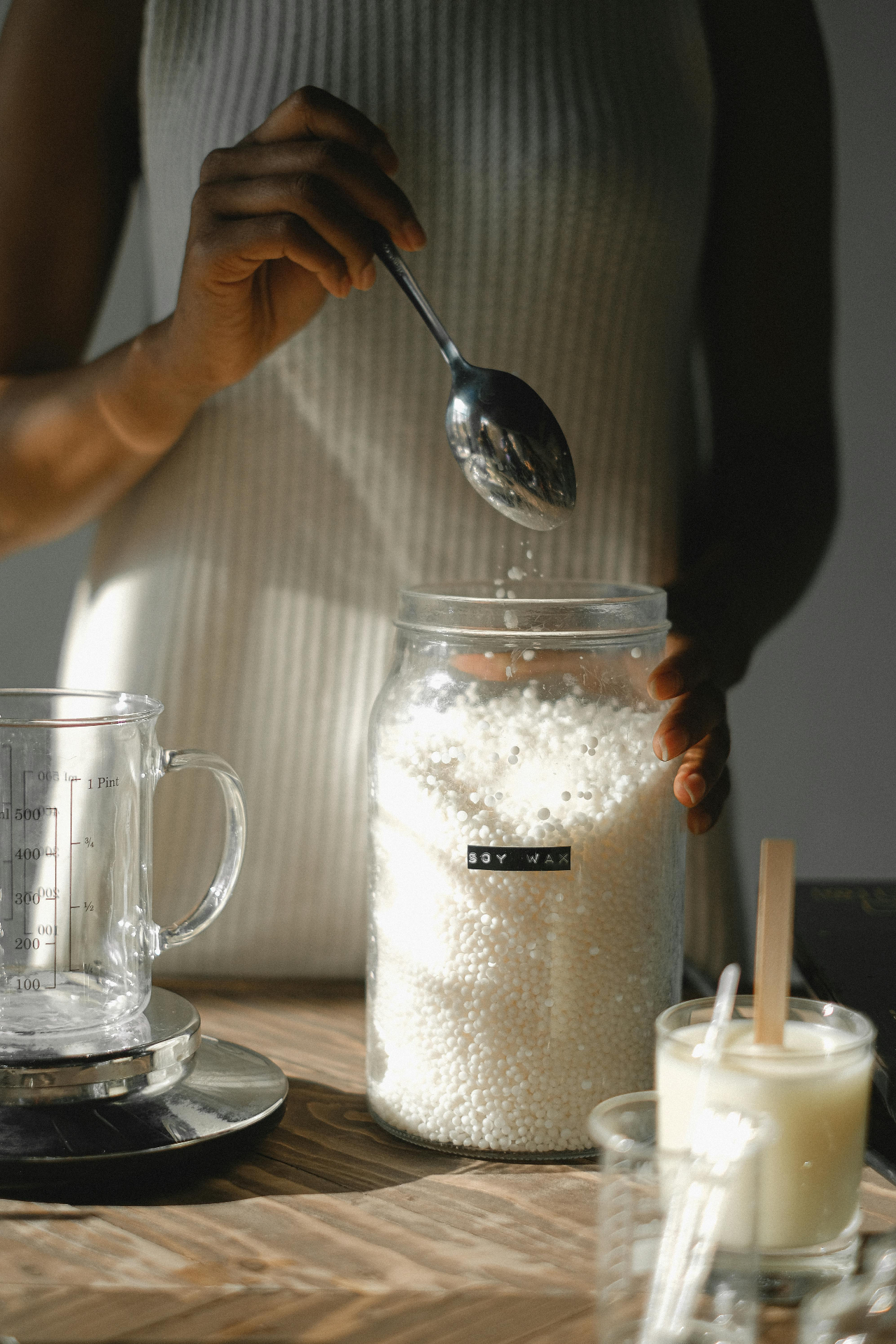 Pouring melted wax into candle containers
