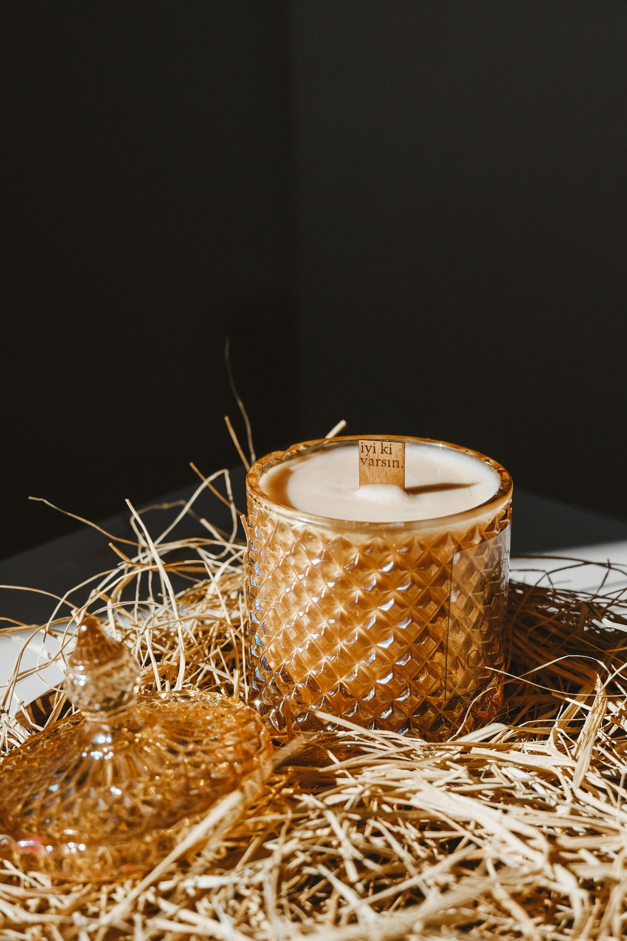 Amber glass candle in decorative straw setting
